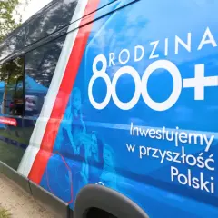 Niebieski van z napisem "Rodzina 800+" i hasłem "Inwestujemy w przyszłość Polski". Widoczne sylwetki rodziny.