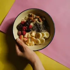 Miseczka owsianki z owocami i orzechami, idealna na śniadanie wspierające dietę bogatoresztkową.