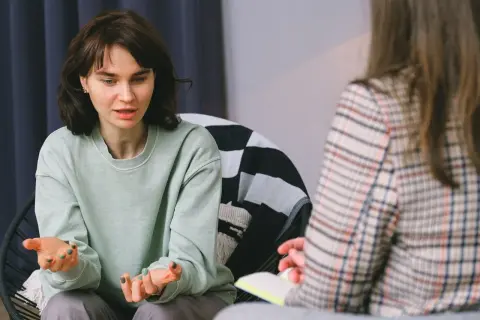 Młoda kobieta opowiada o swoich problemach, co może być początkiem skierowania do psychiatry.