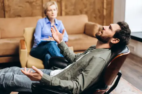 Mężczyzna w gabinecie psychologa, opowiadający o swoich problemach. To może być pierwszy krok, by dowiedzieć się, jak zostać psychologiem.