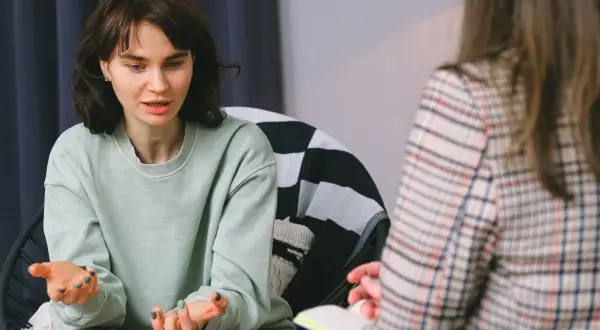 Młoda kobieta opowiada o swoich problemach, co może być początkiem skierowania do psychiatry.
