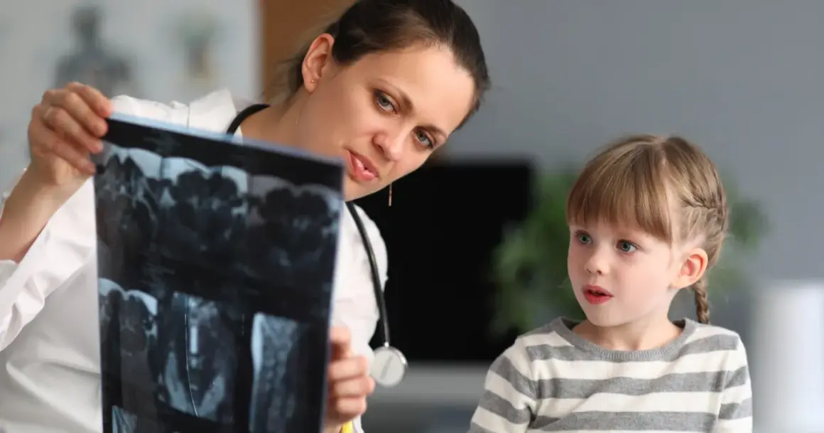 Lekarka, być może neuropsycholog, pokazuje dziecku wyniki rezonansu.