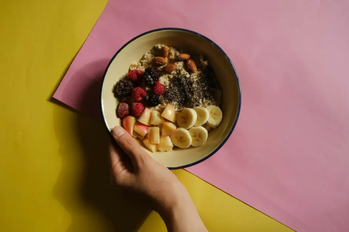 Miseczka owsianki z owocami i orzechami, idealna na śniadanie wspierające dietę bogatoresztkową.