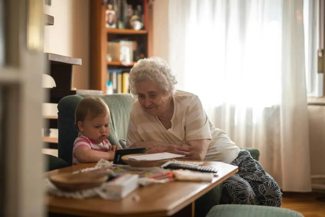 Babcia i wnuczek oglądają coś na tablecie. Ciepłe, rodzinne chwile babciowe.